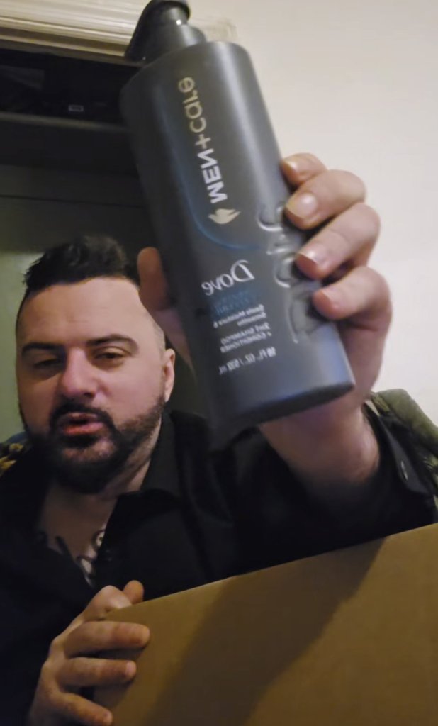 MC Aldin drži bocu Dove Men+Care proizvoda za njegu